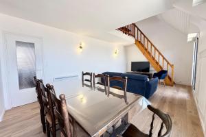 a living room with a table and a blue couch at Duplex plein charme Face mer & déco moderne in Quiberon