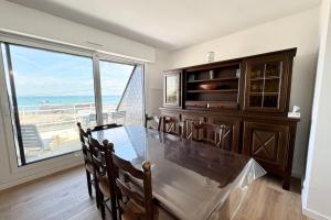 a dining room with a table and a view of the ocean at Duplex plein charme Face mer & déco moderne in Quiberon