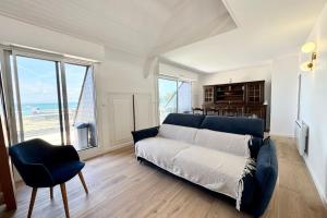 a living room with a blue couch and a table at Duplex plein charme Face mer & déco moderne in Quiberon