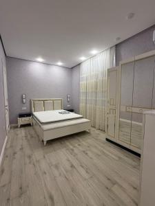 a large room with a bed and wooden floors at Delmar in Baku +9 photos