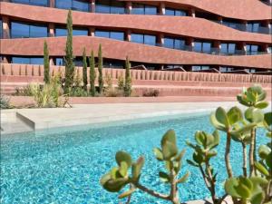 a building with a swimming pool in front of a building at Piscina moderna y elegante 5 in Murcia