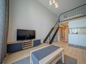 a living room with a television and a staircase at Sky Loft Wrocław Apartment by BookingHost in Wrocław