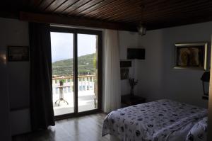 カラブルンにあるTaş Avlu Butik Otelのベッドルーム1室(ベッド1台付)、スライド式ガラスドアが備わります。
