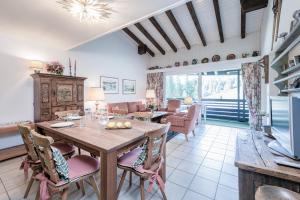 een eetkamer en woonkamer met een tafel en stoelen bij Zuhause in den Alpen Ihre Ferienwohnung mit Hallenbad und Sauna in Lenzerheide