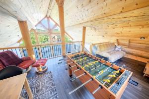 a room with a pool table in a cabin at Chalet en montagne - Spa et Ski - Le Goathouse in Saint-Philémon