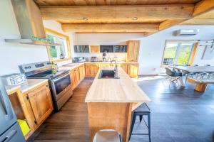 a kitchen with wooden cabinets and a wooden counter top at Chalet en montagne - Spa et Ski - Le Goathouse in Saint-Philémon
