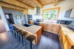 a kitchen with a large island in a cabin at Chalet en montagne - Spa et Ski - Le Goathouse in Saint-Philémon