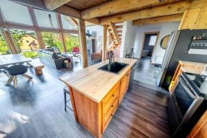 a kitchen and living room in a house at Chalet en montagne - Spa et Ski - Le Goathouse in Saint-Philémon