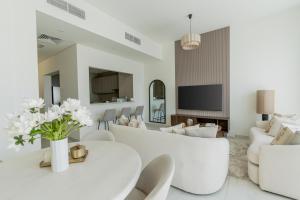 ein Wohnzimmer mit einem weißen Tisch und Stühlen in der Unterkunft Nasma - RAK Bliss 2BR Villa, Maid Room & Backyard in Ras al Khaimah + 48 Fotos