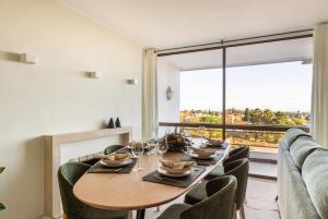 a dining room with a table and chairs and a large window at 3BR Apt w Balcony and Sea View in Cascais