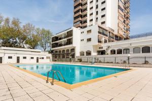 an empty swimming pool in front of a building at 3BR Apt w Balcony and Sea View in Cascais