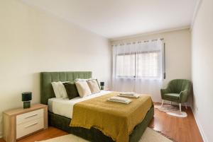 a bedroom with a bed and a chair and a window at 3BR Apt w Balcony and Sea View in Cascais +29 photos