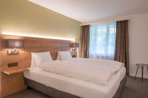 a bedroom with a large white bed and a window at Romantik Hotel & Restaurant Sternen in Kriegstetten