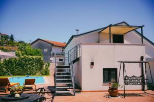 a house with a staircase next to a swimming pool at Casa de Luzes in Amarante