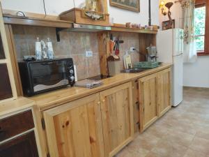 a kitchen with wooden cabinets and a microwave on a counter at Къща за гости Аврамови in Ribarica