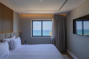 内坦亚Seanergy Boutique & Spa Hotel的一间带床的卧室，可欣赏海景