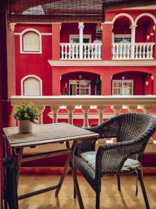 a table and a chair in front of a building at Apartamento rojo con vistas al mar in Mazagón