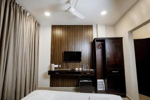 a hotel room with a bed and a desk and a television at The Core Hotel and Restaurant in Kohīma