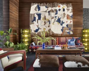 Una sala de estar con un sofá y una lámpara de araña. en Graduate by Hilton Dallas, en Dallas