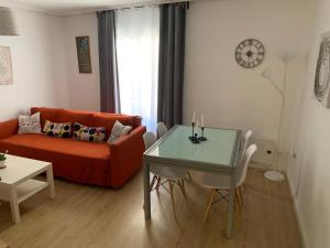a living room with a orange couch and a table at HabitaHost Colón in Cuenca