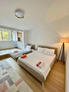 a bedroom with two beds and a large window at Lina Apartment Prizren in Prizren