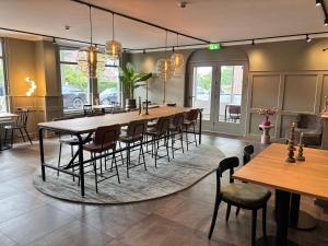 a dining room with a long table and chairs at Het Hart van Weesp in Weesp