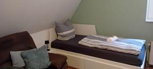 a small bedroom with a bed and a chair at Komplettapartment 4, Küche, WLAN, Parkplatz in Twist