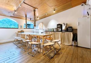 Una cocina con mesa y sillas y un refrigerador. en There B&B, en Jiaoxi