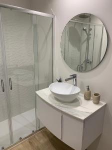 a white bathroom with a sink and a shower at HabitaHost Colón in Cuenca