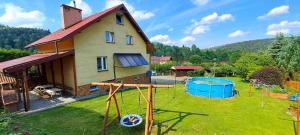 a house with a yard with a pool at Pokoje gościnne u Ewy Cisna in Cisna