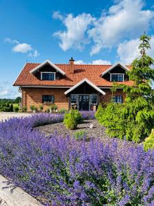 a house with a garden of purple flowers at Lawendowy Domek in Ruciane-Nida