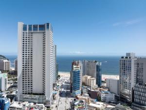 a city with tall buildings and the ocean at Marysol by Haeundae beach in Busan