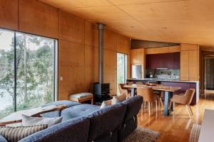 a living room with a couch and a table at Hidden on Huon in Glendevie