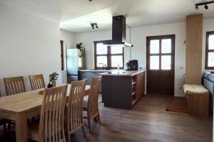 a kitchen and dining room with a table and chairs at La Ferma Nagy in Vişeu de Sus