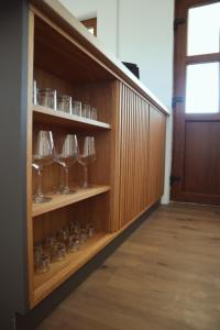 a room with wooden shelves with wine glasses on them at La Ferma Nagy in Vişeu de Sus