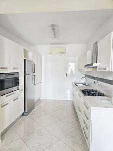 a white kitchen with white cabinets and appliances at Domus Rossetti in Vasto
