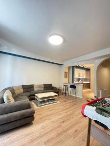 ein Wohnzimmer mit Sofa und Tisch in der Unterkunft Lomi's Homey - Rooms in Tbilisi City