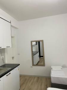 cocina blanca con espejo en la pared en Arval Rooms, en Vlorë