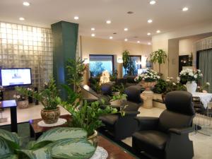 a salon with a waiting room with chairs and plants at Delle Nazioni Milan Hotel in Milan