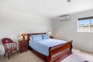 une chambre avec un lit, une chaise et une fenêtre dans l'établissement Country Cottage Sunshine Coast, à Montville