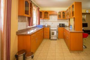 een keuken met oranje kasten en een fornuis met oven bij Ikonia Resort and Hotel in Kisumu