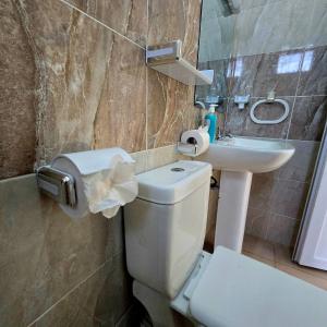 a bathroom with a toilet and a sink at ROYAL MTWAPA House in Mtwapa