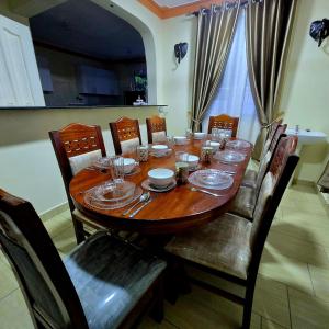 a dining room table with chairs and a wooden tableablish at ROYAL MTWAPA House in Mtwapa