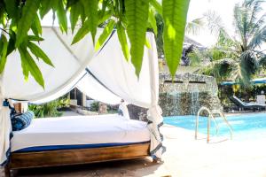 a bed in front of a swimming pool at Wafalme villa in Kwale