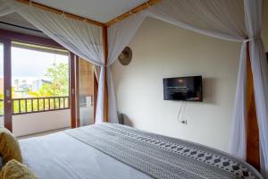チャングーにあるSoleia Surf Camp Baliの壁にテレビが付いたベッドのある寝室