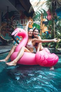 チャングーにあるSoleia Surf Camp Baliの2人の女性がプールの浮き輪に座っている
