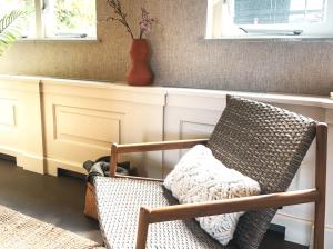 a chair in a living room with a vase at Family Suite, Best Location For Beach Days in Zoutelande