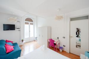 a white room with a blue couch and a desk at A casa di Giulia By Dimorra in Naples