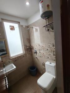 Un baño con inodoro, lavabo y ventana. en Ditvi residency, en Gurgaon