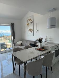 a kitchen and living room with a table and chairs at Perla in Stinica